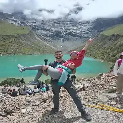 A couple of hikers walking along the Humantay Lagoon trail with panoramic views of the Andes | Inca Culture Travel